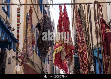 Panni colorati appesi in vendita su un bar a Essaouira Foto Stock