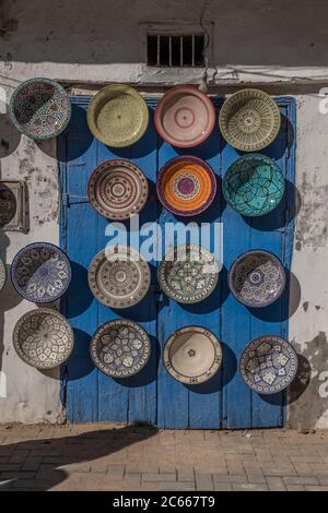 Piatto colorato in una porta blu a Essaouira Foto Stock