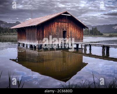 Vecchia casa di barche sul lago Hopfensee nella regione di Allgäu Foto Stock