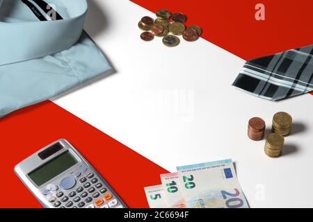 Bandiera austriaca sulla tabella di concetto di denaro minimo. Monete e oggetti finanziari sulla superficie della bandiera. Tema economia nazionale. Foto Stock