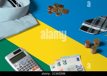 Bandiera del Ruanda sulla tabella di concetto di denaro minimo. Monete e oggetti finanziari sulla superficie della bandiera. Tema economia nazionale. Foto Stock