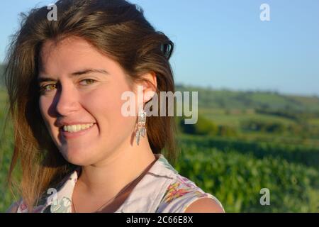 Ritratto di una bella giovane donna all'aperto, sorridente e felice Foto Stock