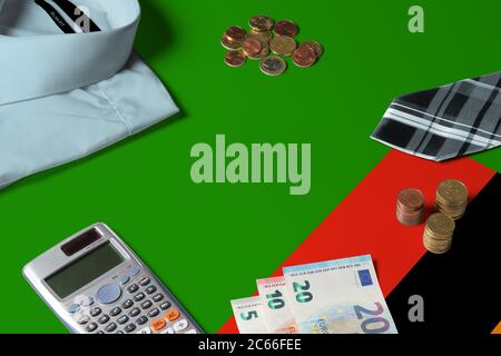 Bandiera Zambia su tabella di concetto di denaro minimo. Monete e oggetti finanziari sulla superficie della bandiera. Tema economia nazionale. Foto Stock