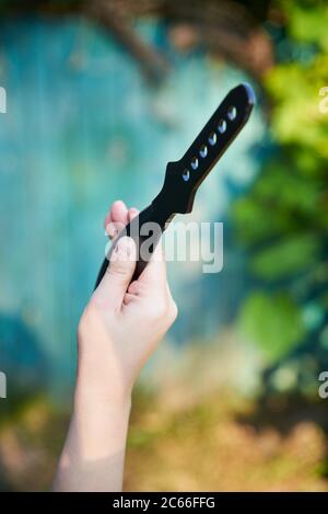 Coltello nero per lanciare in mano una donna, gioco per attività ricreative Foto Stock