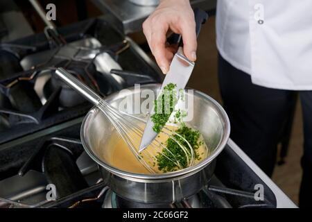 Preparazione della salsa di Béarnaise passo dopo passo, aggiunta di chervil Foto Stock