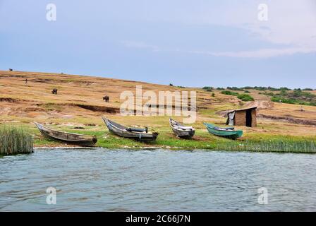 Barche da pesca mostrate al crepuscolo sulla riva del canale di Kazinga. Il canale Kazinga è l'unica fonte di trasporto in questa regione dell'Africa centrale Foto Stock