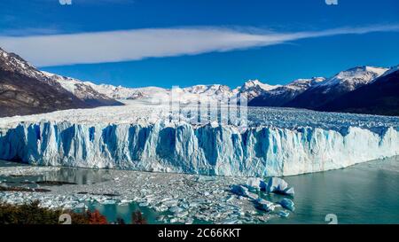 Vista del ghiacciaio Perito Moreno, paesaggio autunnale in primo piano e galleggianti di ghiaccio in acqua, El Calafate, Argentina Foto Stock