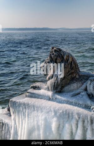 Coperti di ghiaccio Bavarian Lion su un gelido inverno giorno in Tutzing sul Lago di Starnberg, Alta Baviera, Baviera, Germania Foto Stock