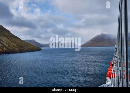 Islanda, fiordi orientali nell'oceano artico, cielo nuvoloso e acqua blu, vista dal traghetto Foto Stock