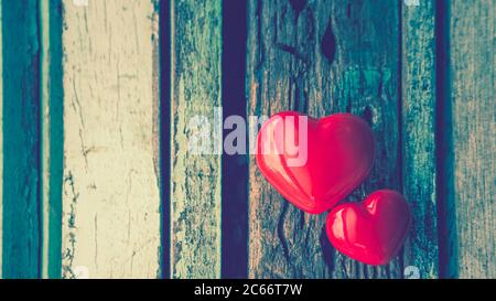 2 cuori rossi posti su un tavolo di legno sfondo in concetto d'amore per san valentino con dolce, romantico momento e giorno di san valentino biglietto d'auguri. Foto Stock