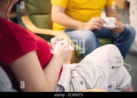 Primo piano di un paio di anziani che insieme trascorrono il tempo in quarantena - caucesi uomo maturo e pensionato, donna che tiene tazze con caffè e tè. Serata accogliente insieme. Stile di vita, domestico, insieme. Foto Stock