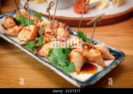 Calamari ripieni cucinati in stile asiatico, primo piano, tondi Foto Stock