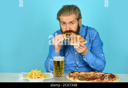 Grazie. Guardando il calcio in TV. fast food americano. Uomo con birra e pizza felice. Cibo italiano. Patatine fritte. Ragazzo al bar che beve un bicchiere di birra e che mangia una pizza. Foto Stock