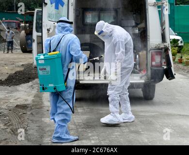 Il lavoratore spruzza disinfettante su un operatore sanitario in un ospedale di fortuna COVID-19, a Khanapara, nel corso del blocco totale imposto dal governo di Assam per frenare la diffusione del novo coronavirus, a Guwahati, Assam, India, venerdì 03 luglio 2020. Foto Stock