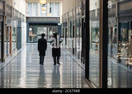 Glasgow, Scozia, Regno Unito. 7 luglio 2020. Due dei concierge camminano insieme lungo il centro commerciale Argyll Arcade. I negozi sono autorizzati a riaprire per affari con l'ulteriore allentamento delle regole di blocco del coronavirus. Credito: SKULLY/Alamy Live News Foto Stock