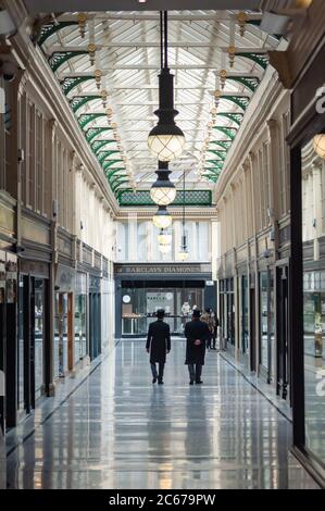 Glasgow, Scozia, Regno Unito. 7 luglio 2020. Due dei concierge camminano insieme lungo il centro commerciale Argyll Arcade. I negozi sono autorizzati a riaprire per affari con l'ulteriore allentamento delle regole di blocco del coronavirus. Credito: SKULLY/Alamy Live News Foto Stock