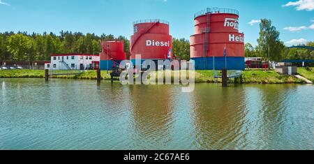 Gifhorn, Germania, 15 maggio 2020: Grandi serbatoi rossi con gasolio nel porto sul canale Foto Stock