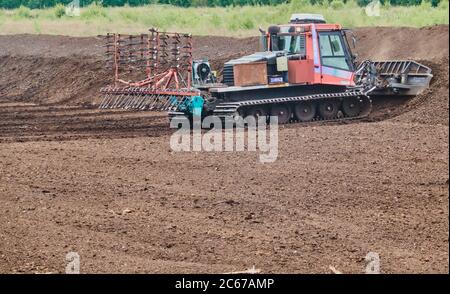 Gifhorn, Germania, 15 maggio 2020: Macchina grande per tagliare, allentare e spingere insieme la torba dopo che il terreno di torba è stato asciugato Foto Stock