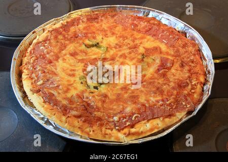 Pizza fatta in casa appena sfornata con salsa di pomodoro al formaggio fuso e un fungo in un vassoio di alluminio appena fuori dal forno. Vista dall'alto, dep. Poco profonda Foto Stock