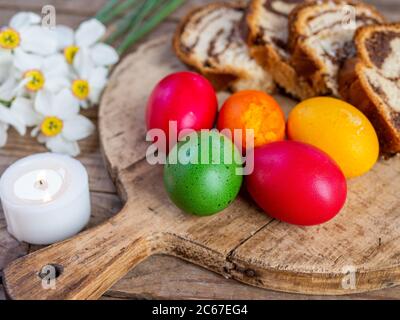 tradizionale rumeno piatto pasquale cozonac o animelle su tavola di legno e colorato uova di pasqua e fiori Foto Stock