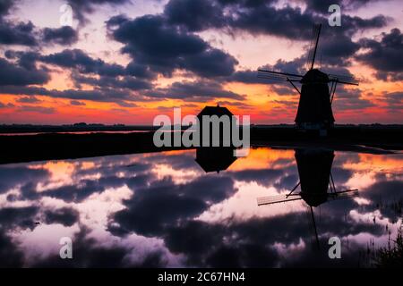 Vecchio mulino a vento olandese "Het Noorden" sull'isola di Wadden Texel, Paesi Bassi, con un meraviglioso cielo luminoso al tramonto sullo sfondo. Foto Stock