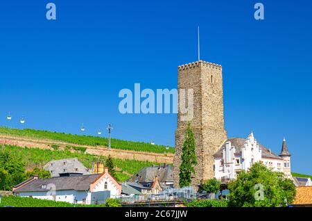 Edificio in pietra torre, funivia sopra i campi di vigneti delle colline della Valle del Reno in Rudesheim am Rhein centro storico, cielo blu sfondo, stato dell'Assia, Germania Foto Stock