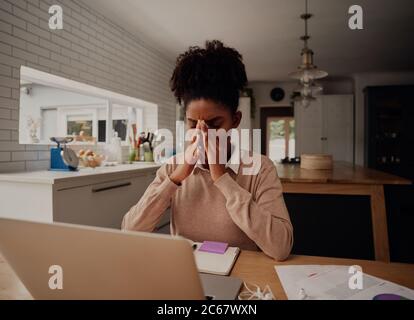 Donna d'affari afro-americana stressante che tiene il ponte nasale, che soffre di sindrome degli occhi secchi dopo un lungo uso del computer portatile Foto Stock