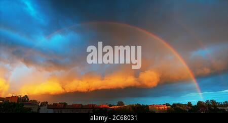 Panorama di nubi tempeste e arcobaleno pieno nel sole che tramonta Foto Stock