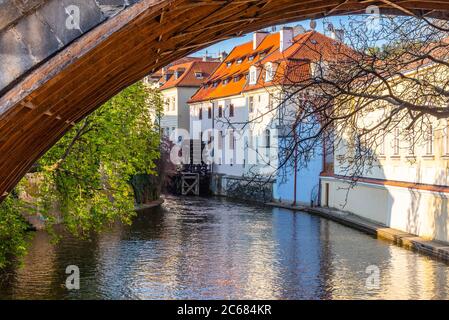 Vecchia ruota del mulino ad acqua sotto il Ponte Carlo, il fiume Certovka, Praga, Repubblica Ceca. Foto Stock