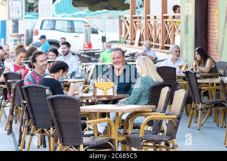 Punta Umbria, Huelva, Spagna - 3 luglio 2020: Persone sedute in terrazza di un bar e caffetteria in via calle Ancha di Punta Umbria Foto Stock