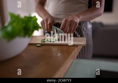 Cetriolo froped black lady mentre cucinando piatto sano per cena a casa Foto Stock