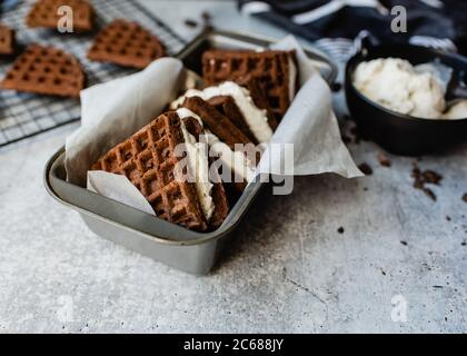 Panini fatti in casa con gelato e i loro ingredienti sul banco di pietra. Foto Stock