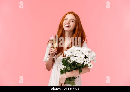 Attraente, allegro b-day ragazza con capelli ricci rossi, ridendo e guardando la macchina fotografica spensierata come parlare con gli amici durante la festa, festa di compleanno Foto Stock