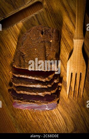 Carne indurita su un tagliere di legno Foto Stock