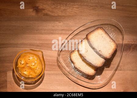 Kumquat canditi e fette di torta di agrumi su lastre di vetro, su una superficie di legno. Vista dall'alto Foto Stock