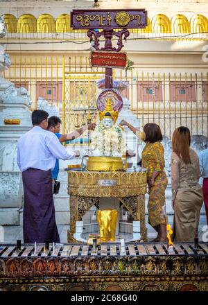 I devoti fanno offerte al Santuario del Mercoledì mattina nella Pagoda di Shwedagon, Yangon, Myanmar Foto Stock