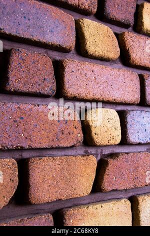 Vista da un angolo laterale di mattoni fianco a fianco - su una parete. La parte anteriore della foto muro di mattoni Foto Stock