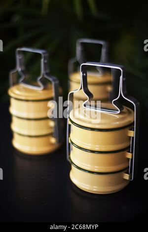 supporti tiffin gialli a 3 livelli su sfondo nero Foto Stock
