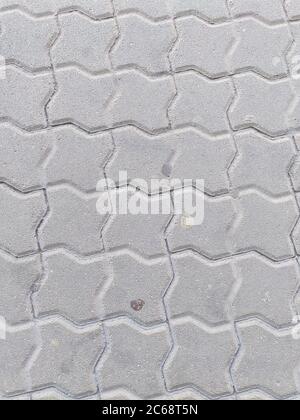 Pavimenti in piastrelle grigio urbano con gomma da masticare, vista dall'alto. Sfondo geometrico grigio. Foto Stock