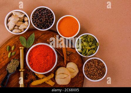 Diversi tipi di spezie in piccoli piatti con colori diversi insieme dalla vista dall'alto. Foto Stock