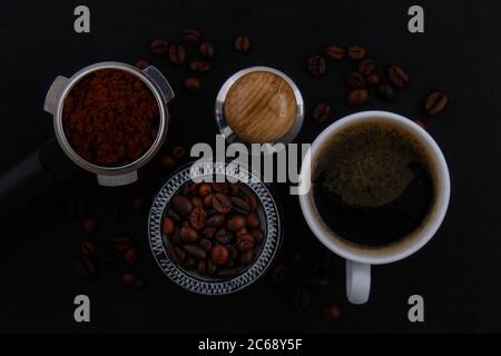 Chicchi di caffè bianchi e neri con fondo nero. Foto Stock
