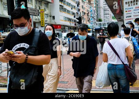 Hong Kong. 8 luglio 2020. La gente cammina per strada con la maschera chirurgica come Hong Kong sta combattendo contro potenzialmente una terza ondata di infezioni da coronavirus, come nove dei 14 nuovi casi il martedì sono stati classificati come locali. Credit: Keith Tsuji/ZUMA Wire/Alamy Live News Foto Stock