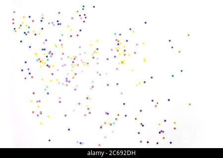 Stelle multicolore su sfondo bianco. Sfondo festoso di colorate stelle di confetti su sfondo bianco. Foto Stock