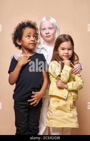 ritratto di adorabili bambini diversi isolati: neri africani, albini ed europei si levano insieme, stretta amicizia tra loro. persone tuffarsi Foto Stock