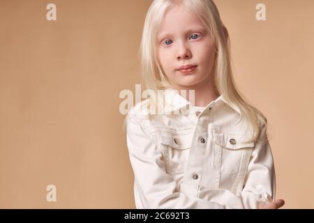 adorabile albino ragazza 7-9 anni in posa a macchina fotografica isolata. timido bambino caucasico con insoliti capelli biondi naturali e pelle bianca nata con alb Foto Stock