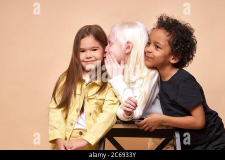 due diverse amiche condividono segreti tra loro, il ragazzo cerca di evesdrop il loro segreto, concetto di bambini Foto Stock