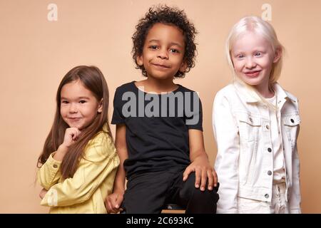 diversi sorridenti positivi bambini che posano alla macchina fotografica, felice nero ragazzo e albino, caucasiche ragazze felici insieme, stretta amicizia internazionale. isolat Foto Stock