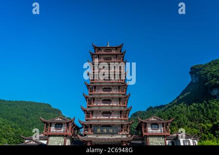 Zhangjiajie, Cina - Agosto 2019 : Torre di legno in stile cinese tradizionale pagoda in piedi all'entrata di Wulingyuan al parco nazionale di Zhangjiajie Foto Stock