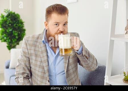 Guardare la fotocamera online. Divertente uomo con un bicchiere di birra sorride agli amici online video chat call webcam conferenza home applicazione. Foto Stock