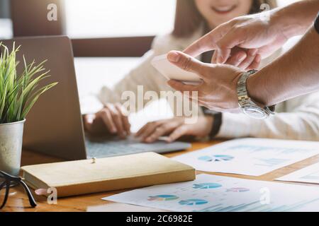 Incontro con il consulente asiatico per analizzare e discutere la situazione sul rapporto finanziario con la calcolatrice. Foto Stock